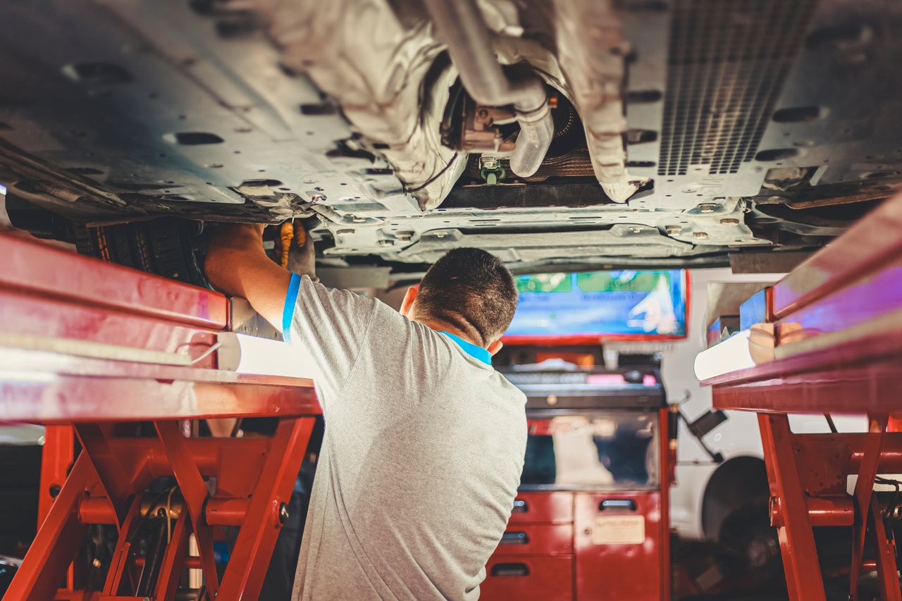 Techniker bei der Fahrzeugdiagnose auf der Hebebühne